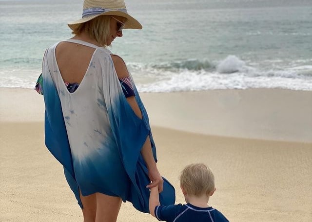 Photos of Michelle Beisner-Buck and her son. She is wearing white and blue color dress.